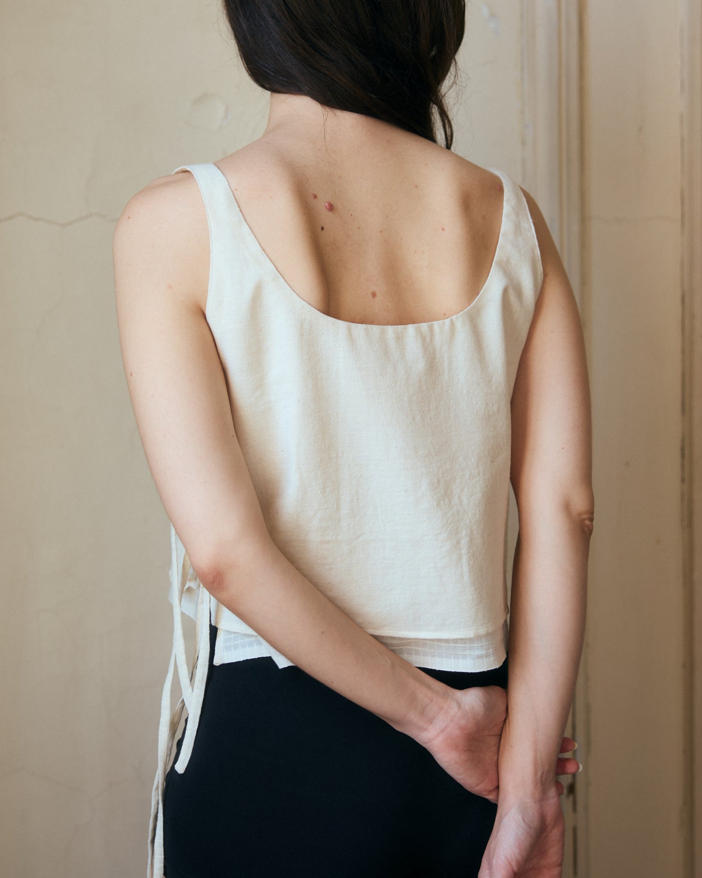 Light white cotton summer top. Back view showing wide and low neckline.