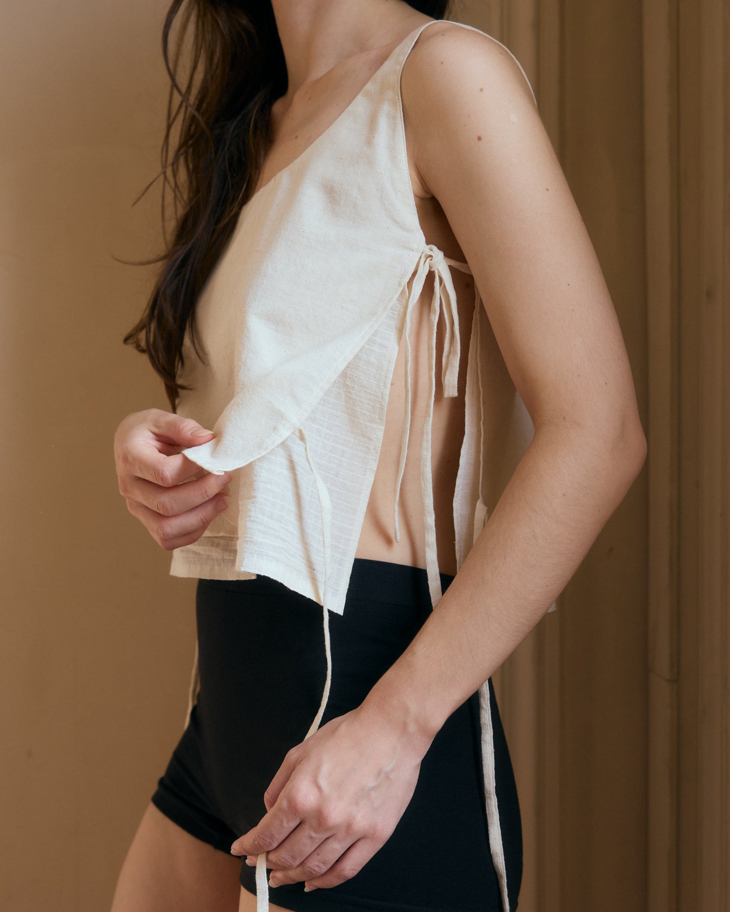 Side view of white cotton top, showing the two layers and the side ties.